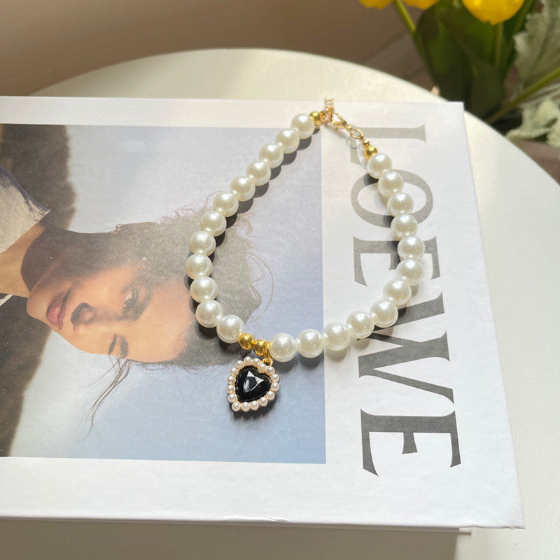 Pearl necklace with a heart-shaped pendant on a magazine