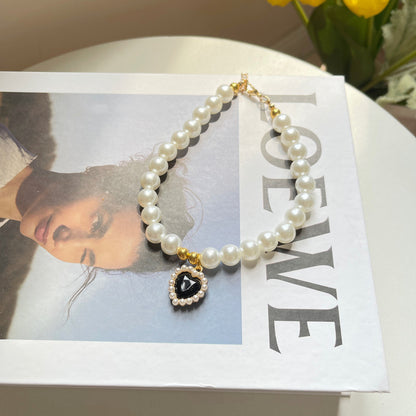 Pearl necklace with a heart-shaped pendant on a magazine