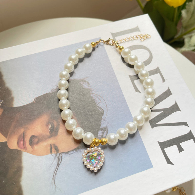 Pearl bracelet with a heart-shaped charm on a magazine