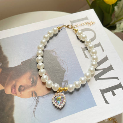 Pearl bracelet with a heart-shaped charm on a magazine