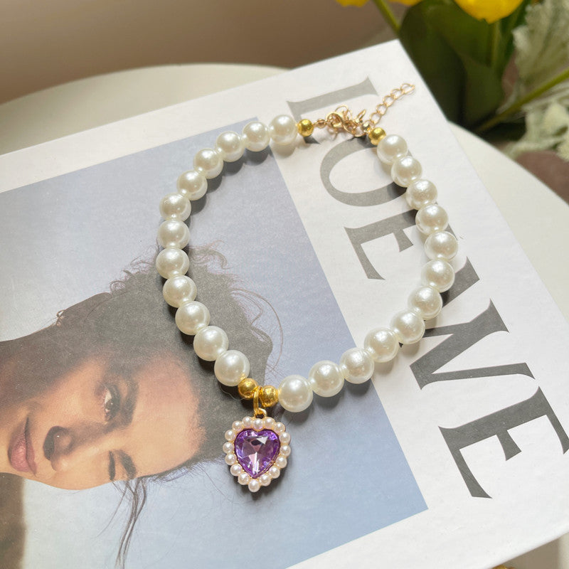 Pearl bracelet with a purple heart charm on a magazine