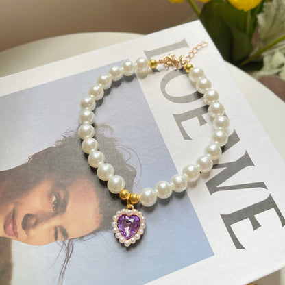 Pearl bracelet with a purple heart charm on a magazine